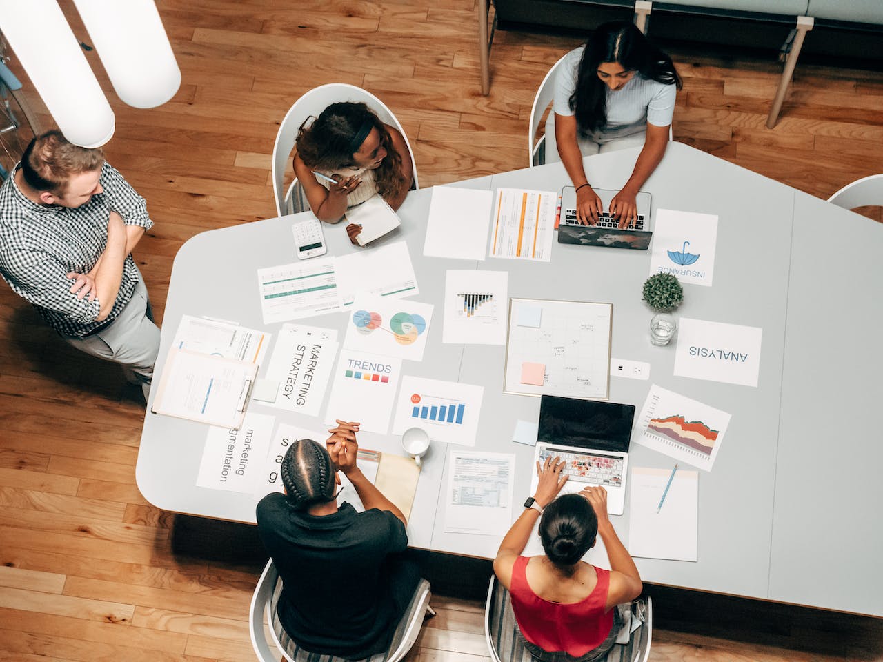 Birds eye view of multiple different workers in an office around a table