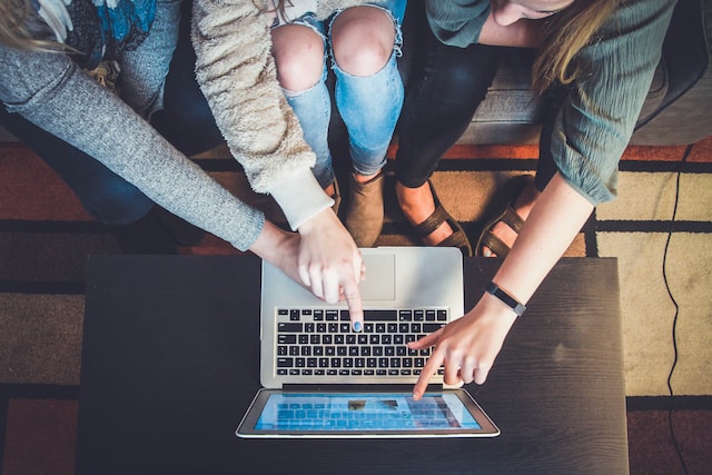 people pointing at laptop screen